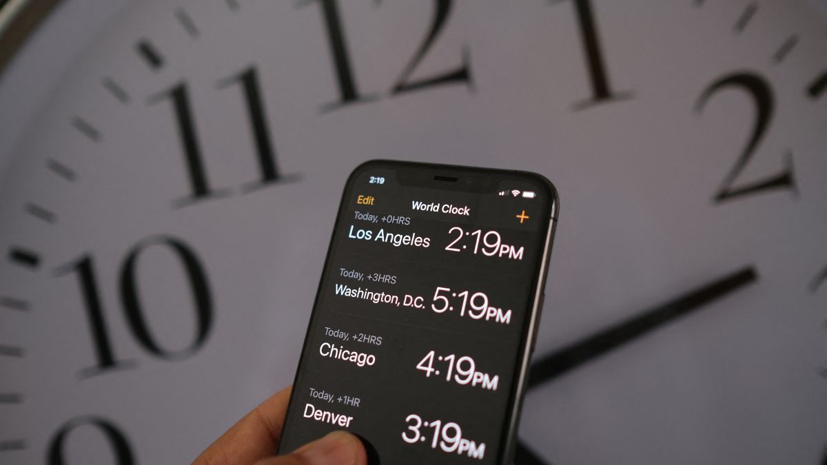 This photo shows a clock in the background of a smartphone showing the time after daylight saving time was implemented in Los Angeles, California, on March 15, 2022. AFP
This photo shows a clock in the background of a smartphone showing the time after daylight saving time was implemented in Los Angeles, California, on March 15, 2022. AFP