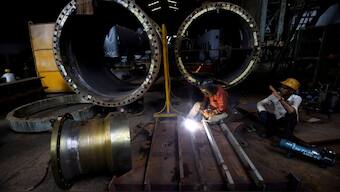 A worker welds a cooling coil plate inside an industrial manufacturing unit on the outskirts of Ahmedabad, India, July 23, 2024. (Photo: Reuters)