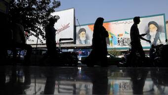 People walk past a mural depicting the late leader of the Islamic Revolution Ayatollah Ruhollah Khomeini and Iran's Supreme Leader Ayatollah Ali Khamenei on a building in a street in Tehran. (Photo: Reuters)