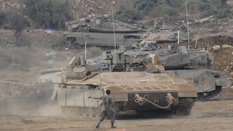 Israeli armoured personnel carriers (APC) and tanks manoeuvre in a staging area in northern Israel near the Israel-Lebanon border. AP