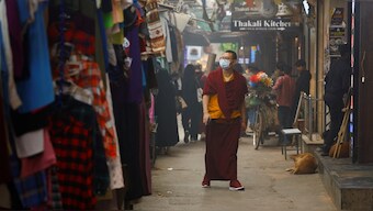A monk wearing a protective mask walks in a market as the sky is enveloped with smog after Delhi's air quality turned "hazardous" due to alarming air pollution, in New Delhi, India, November 18, 2024. Reuters