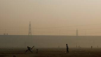 Men play cricket on a ground as the sky is enveloped with smog after Delhi's air quality worsened due to air pollution in New Delhi on November 20, 2024. Reuters
