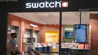 A man walk pass Swatch outlet at a shopping mall in Putrajaya, Malaysia. AP