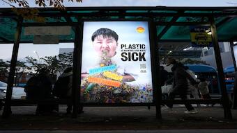 A display board shows a call for a reduction in plastic production during the fifth session of the Intergovernmental Negotiating Committee on Plastic Pollution, at a taxi station in Busan, South Korea. AP