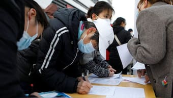 Job seekers visit a booth at a job fair in Beijing, China. Source: REUTERS | FILE.