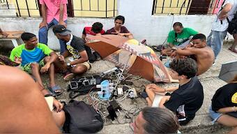 People charge their mobile phones in the aftermath of Hurricane Rafael, which affected the electricity service, near Havana. AFP