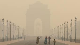 Women walk on a road near India Gate as the sky is enveloped with smog after Delhi's air quality worsened due to air pollution. November 19, 2024. Source: Reuters.