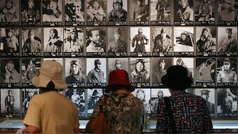 Three people look at photos of Japanese kamikaze pilots in a museum display in Chiran on June 6, 2007. (Photo: AP)