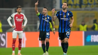 Inter Milan's Hakan Calhanoglu (right) celebrates after successfully converting a penalty during the UEFA Champions League match against Arsenal. AP