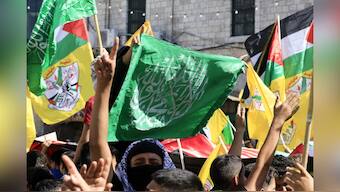 People wave Palestinian, Hamas and Fatah flags during a march in support of the people in the Gaza Strip, in the West Bank city of Nablus. AFP
