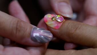 Japanese manicurist Naomi Arimoto presses a false nail with a decorative nail tip using plastic waste, which she collected from the beach onto a thumb of a customer at her nail salon in Chigasaki, Kanagawa Prefecture, Japan. Reuters