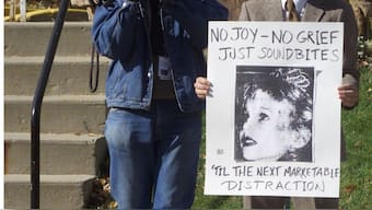 A lone protestor is recorded by a television cameraman outside the Boulder County courthouse as the grand jurors in the JonBenet Ramsey murder case were meeting, October 12, 1999. File Image/Reuters