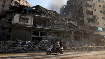 People ride a scooter past damaged buildings, in the aftermath of Israeli strikes on Beirut's southern suburbs, during a Hezbollah media tour, amid the ongoing hostilities between Hezbollah and Israeli forces, Lebanon, on November 9, 2024. Reuters File