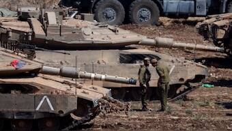 Israeli members of the military stand next to armoured vehicles, amid cross-border hostilities between Hezbollah and Israel, in northern Israel, September 30, 2024- Image - Reuters