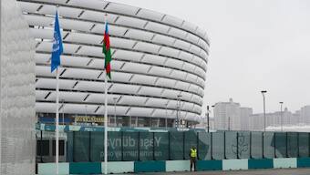 A member of security stands with the Baku Olympic Stadium in the background during the COP29 U.N. Climate Summit, Saturday, Nov. 23, 2024, in Baku, Azerbaijan. Image- AP