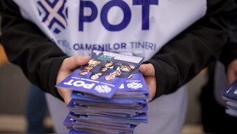 A man distributes leaflets of the Young People's Party or POT, which has backed Calin Georgescu, an independent candidate who won the first round of presidential elections, in Bucharest, Romania. AP