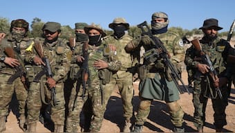 Syrian opposition fighters stand in formation after entering the village of Anjara, western outskirts of Aleppo, Syria, on Thursday, part of their major offensive on government-controlled areas in the country's northwestern Syria. AP