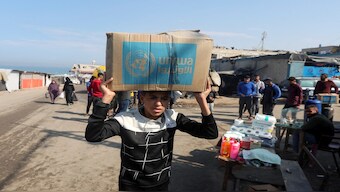 A Palestinian carries an aid box distributed by the United Nations Relief and Works Agency (UNRWA), amid the Israel-Hamas conflict, in Deir Al-Balah, central Gaza Strip, on November 4, 2024. Reuters File