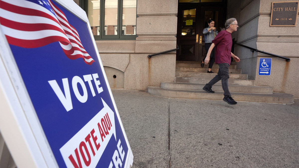 (File) People walk past a sign that points the direction toward a voting location during early voting in the general election on November 1, 2024, at City Hall in Providence, R.I. AP (File) People walk past a sign that points the direction toward a voting location during early voting in the general election on November 1, 2024, at City Hall in Providence, R.I. AP