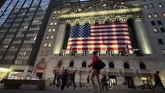 FILE - People pass the New York Stock Exchange on Nov. 5, 2024, in New York. AP