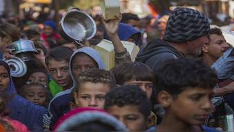 Palestinian children queue for donated food in Deir al-Balah, Gaza Strip. Some hope that the Lebanon ceasefire will bring about a change in Gaza too. AP