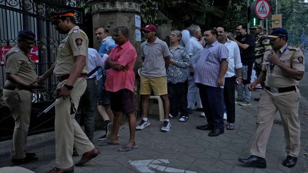People queue to cast their votes, outside a polling station, as police officers stand guard on the day of the Maharashtra state elections, in Mumbai. Reuters People queue to cast their votes, outside a polling station, as police officers stand guard on the day of the Maharashtra state elections, in Mumbai. Reuters
