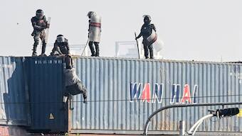 Paramilitary soldiers try to detain a supporter of the Pakistan Tehreek-e-Insaf (PTI) party on top of a shipping container during a protest demanding the release Imran Khan, at the Red Zone area in Islamabad. AFP