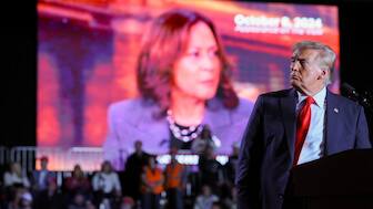 Donald Trump looks on as a screen shows Kamala Harris during a campaign rally at Macomb Community College in Warren, Michigan, US, November 1. Trump defeated Harris and has returned to power in the US. Reuters