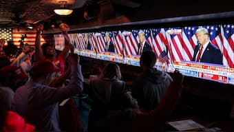 Supporters of Donald Trump react next to screens showing him speak from the Palm Beach County Convention Center, as they attend the New York Young Republican Club watch party during the 2024 US presidential election, in Manhattan, New York City. The Republican nominee is on course to win the election. Reuters
