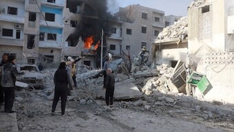 White Helmets members work next to a damaged building at the scene of what the organisation says is a strike, at a location given as Idlib, Syria. Reuters