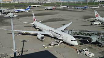 (FILES) This photo taken on August 24, 2024 shows a Japan Airlines (JAL) Boeing 787-9 Dreamliner passenger jet (C) sitting at a gate at Tokyo International Airport at Haneda. AFP