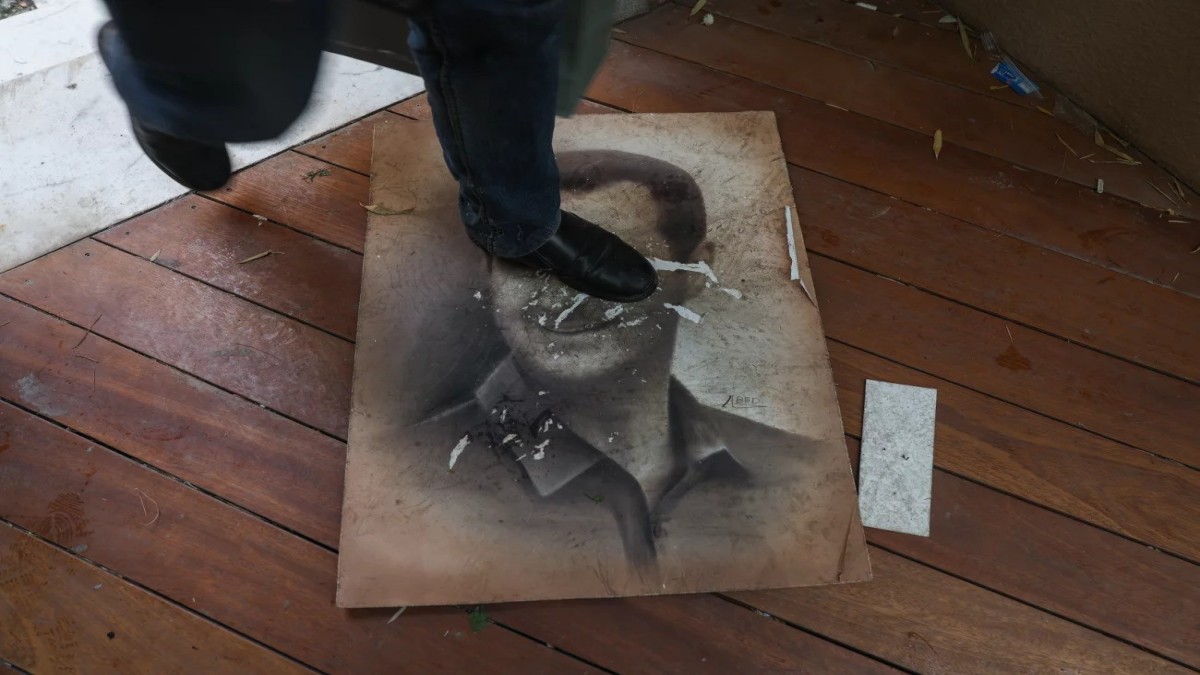 A man steps on an image of Syria’s deposed president, Bashar al-Assad, as people enter his home in the Malki neighborhood of Damascus. This follows a swift offensive by Islamist-led rebels, who declared they had captured the Syrian capital, forcing al-Assad to flee and bringing an end to the five decades of Baath rule in Syria.
Image: Omar Haj Kadour/AFP  A man steps on an image of Syria’s deposed president, Bashar al-Assad, as people enter his home in the Malki neighborhood of Damascus. This follows a swift offensive by Islamist-led rebels, who declared they had captured the Syrian capital, forcing al-Assad to flee and bringing an end to the five decades of Baath rule in Syria.
Image: Omar Haj Kadour/AFP