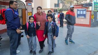 Students leave with their guardians after schools in Delhi received a bomb threat mail. Source: PTI. 