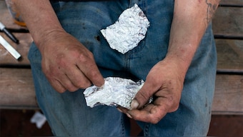 (File) A man prepares to smoke fentanyl on a park bench. AP