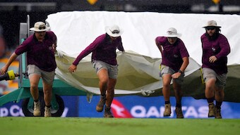 Ground staff at the Brisbane Cricket Ground, a.k.a. 'The Gabba', bring out the covers on the opening day of the third Test between Australia and India. Reuters