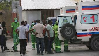 Medics inspect an ambulance of wounded people, shot by armed gangs at the General Hospital, in Port-au-Prince, Haiti. AP