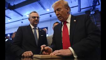 Donald Trump, right, signs autographs as Massad Boulos watches during a visit to Dearborn, Michigan on November 1, 2024. AP