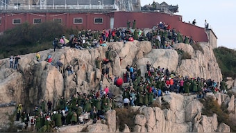 Tourists crowd on the mountain edge as they watch a sunrise on a peak of Mount Tai, on the first day of the seven-day national day holiday, in Tai'an, Shandong province, October 1, 2014. File Image/Reuters