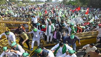 Farmers and Kisan Ekta Sangh members break police barricades during their protest march demanding for the expansion of minimum support prices (MSP) and other benefits, in Noida, Monday, December 2, 2024. PTI