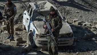 Taliban security personnel stand guard near a damaged car two days after air strikes by Pakistan in the Barmal district of eastern Paktika province on December 26, 2024. Image- AFP