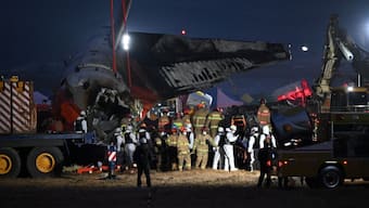 Firefighters and rescue personnel carry the body of a victim near the scene where a Jeju Air Boeing 737-800 series aircraft crashed and burst into flames at Muan International Airport in South Jeolla Province, some 288 kilometres southwest of Seoul on December 29, 2024. Image-AFP