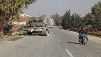 A motorcycle passes a tank, after rebels led by HTS have sought to capitalize on their swift takeover of Aleppo in the north and Hama in west-central Syria by pressing onwards to Homs, in Hama, Syria on Friday. Reuters 