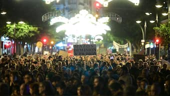 Protesters hold banners to demand resignation of the Valencian regional president Carlos Mazon over his handling of October floods, in front of Valencia's bull ring. AFP