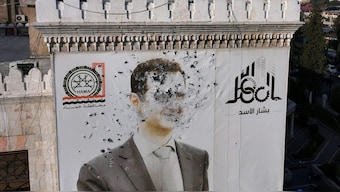 This aerial picture shows a bullet-riddled portrait of Syrian President Bashar al-Assad adorning Hama's municipality building after it was defaced following the capture of the city by anti government fighters. AFP