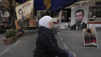 Shoes hanging in front of portraits of ousted Syrian President Bashar Assad in Damascus, Syria. AP