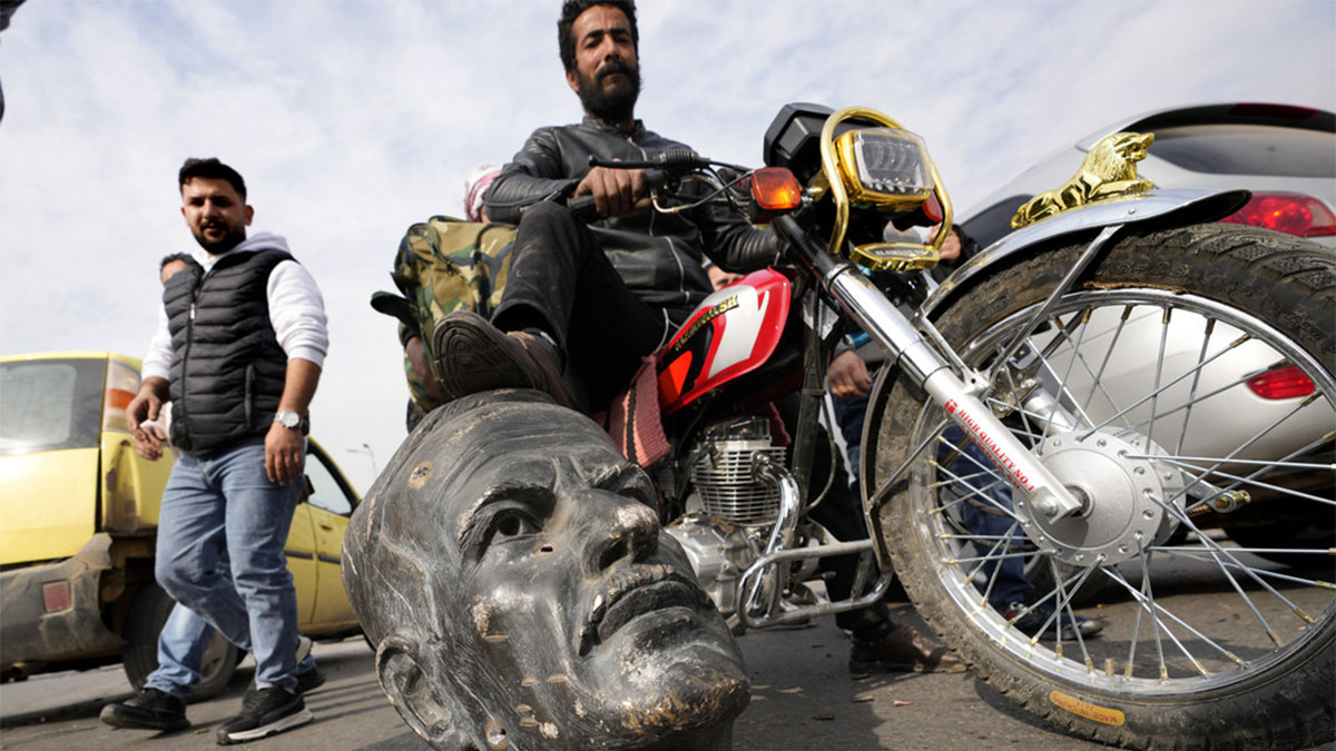 An opposition fighter riding a motorcycle steps on a broken bust of the late Syrian President Hafez Assad, in Damascus, Syria, on December 8, 2024. AP An opposition fighter riding a motorcycle steps on a broken bust of the late Syrian President Hafez Assad, in Damascus, Syria, on December 8, 2024. AP