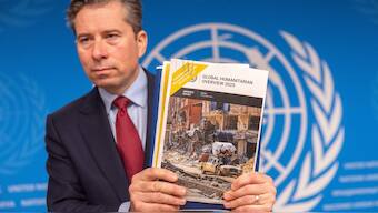 Tom Fletcher, United Nations Under-Secretary-General for Humanitarian Affairs and Emergency Relief Coordinator (OCHA) holds a copy of the Global Humanitarian overview after a press conference in Geneva, Switzerland. Reuters