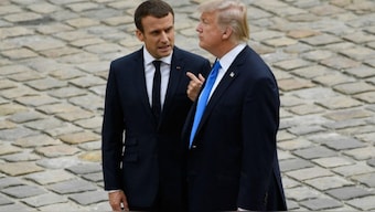 File photo of French President Emmanuel Macron (L) talking to Donald Trump during a welcome ceremony at Les Invalides in Paris on July 13, 2017. Source: AFP.