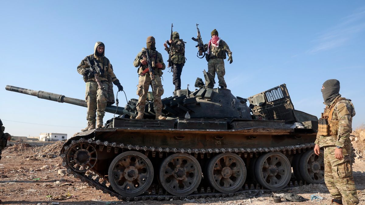 Syrian opposition fighters stand atop a seized military armored vehicle on the outskirts of Hama, Syria, December 3, 2024. AP Syrian opposition fighters stand atop a seized military armored vehicle on the outskirts of Hama, Syria, December 3, 2024. AP