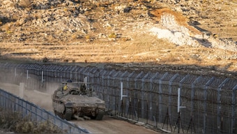 An Israeli armoured vehicle maneuvers along the security fence near the so-called Alpha Line that separates the Israeli-controlled Golan Heights from Syria, in the town of Majdal Shams, December 15, 2024. AP